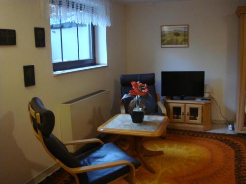 sala de estar con mesa, sillas y TV en Messezimmer, en Ratingen