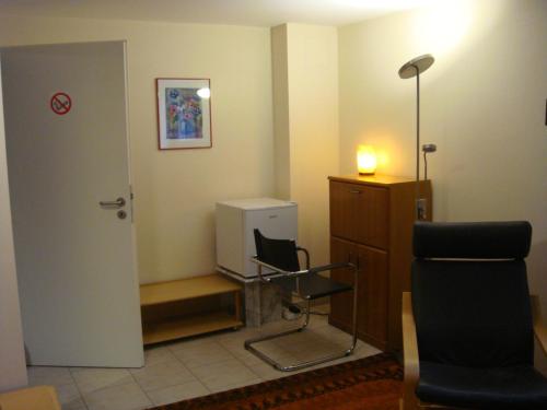 a waiting room with a chair and a cabinet at Messezimmer in Ratingen