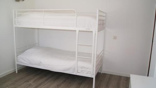 a white bunk bed in a white room at Apartamento Próximo da Praia in Luz