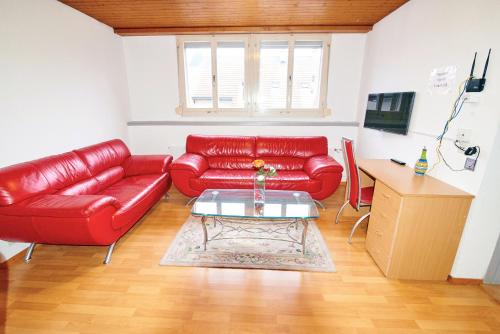 a living room with a red couch and a table at Ferrari Apartment in Interlaken