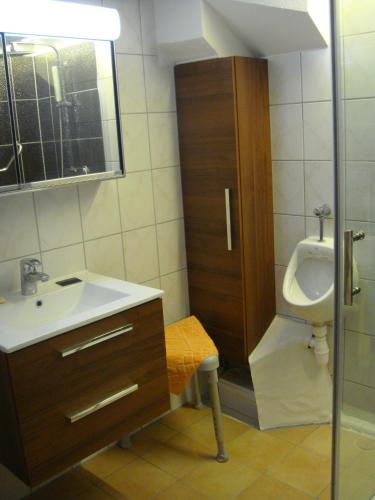 a bathroom with a sink and a toilet and a urinal at Messezimmer in Ratingen