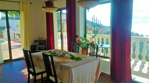 a dining room with a table and chairs and a balcony at Ashram Villa Sunshine in Sitges