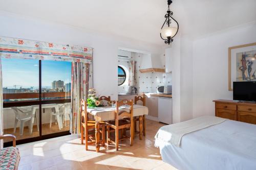 Un dormitorio con una cama y una mesa y una cocina. en Mirachoro Portimao, en Portimão
