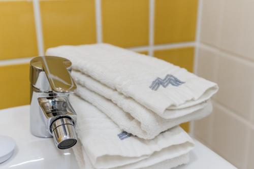una pila de toallas encima de un lavabo en Mirachoro Portimao, en Portimão