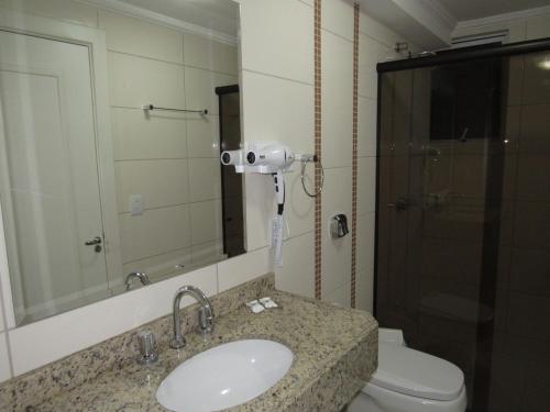 拉熱阿杜的住宿－HOTEL MARIANI，一间带水槽、卫生间和镜子的浴室