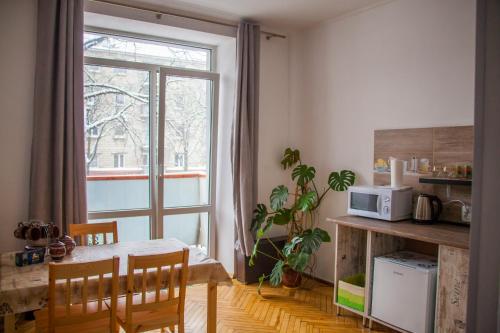 een keuken met een tafel en een raam bij ART ApartmenT in Ternopilʼ