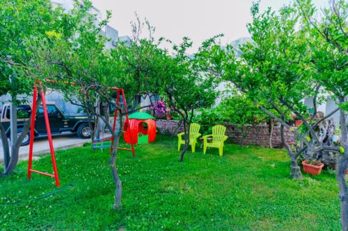 a yard with a swing set in the grass at Apartments SoleMar2 in Sutomore