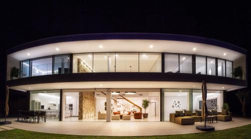 a large house with glass windows at night at Villa Alkaram de lujo con vistas panorámicas al mar in Zahara de los Atunes