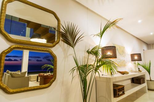a living room with a mirror and a plant at Villa Alkaram de lujo con vistas panorámicas al mar in Zahara de los Atunes