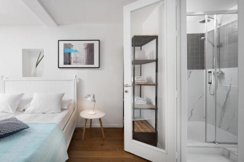 biała sypialnia z łóżkiem i prysznicem w obiekcie Old Town Rovinj Apartments by Irundo w Rovinj