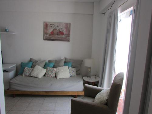 uma sala de estar com um sofá e duas cadeiras em Departamento Tango & Resto-Hospital Ital y Sanatorio Güemes em Buenos Aires