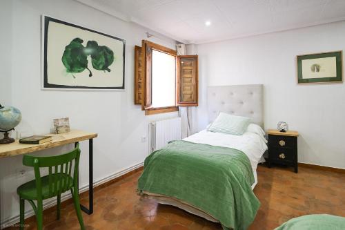 a bedroom with a bed and a desk and a chair at Apartamento LA CATEDRAL CUENCA in Cuenca