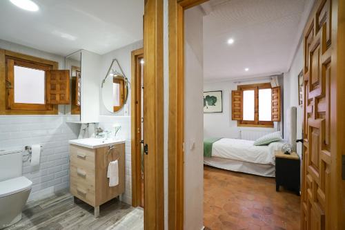 a bathroom with a toilet sink and a bed at Apartamento LA CATEDRAL CUENCA in Cuenca