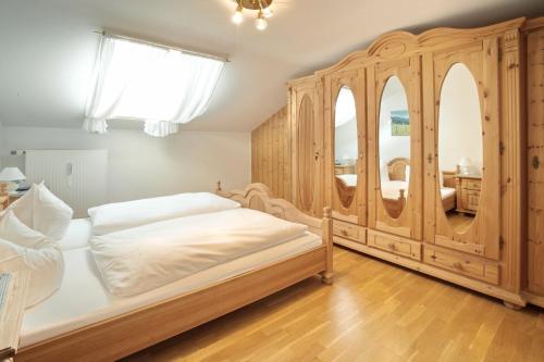- une chambre avec un lit en bois et une grande armoire en bois dans l'établissement Bergblick, à Fischen im Allgäu