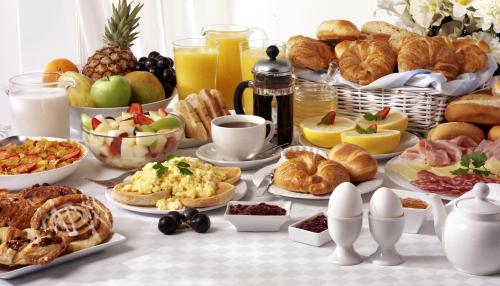 a breakfast table with croissants and other breakfast foods at Hotel Luckys Inn in Hamburg