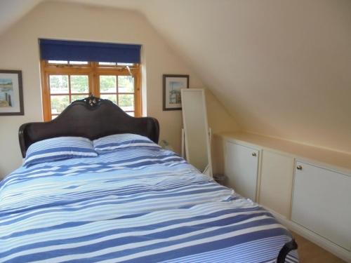 Schlafzimmer mit einem Bett mit blauen und weißen Streifen in der Unterkunft Sail Loft in Eastbourne