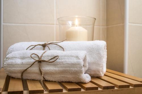 a stack of towels on a table with a candle at A casa mia in Saronno