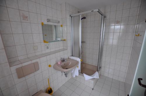 a bathroom with a sink and a shower at Landhotel Weisses Röß`l in Adorf