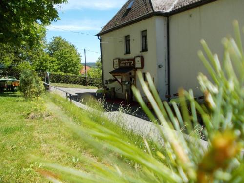 a house in a field with grass in front of it at Landhotel Weisses Röß`l in Adorf