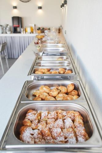 a buffet line with trays of donuts and pastries at Albatros Suites in Nea Vrasna