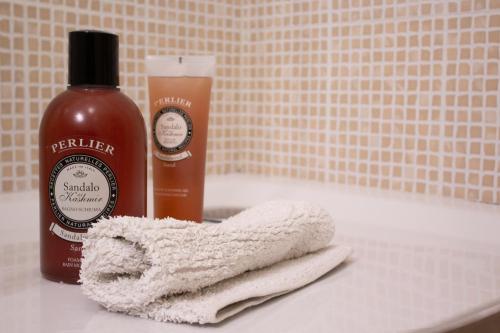 a bottle of shampoo and a towel on a bathroom sink at A casa mia in Saronno