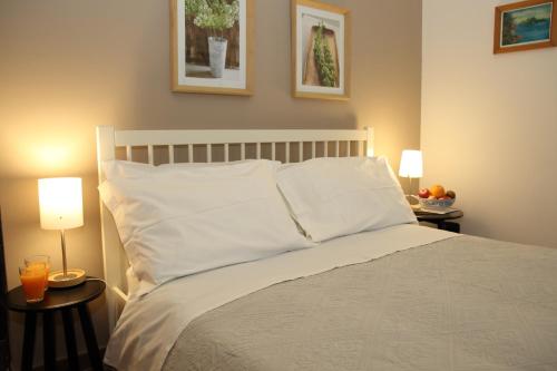 カターニアにあるサ バルベーロ チャルメ B & Bのベッドルーム1室(白い枕とランプ2つ付)