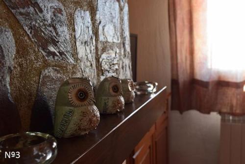 una fila de jarrones sentados en un estante junto a una pared en Los Ayales, en Huelamos
