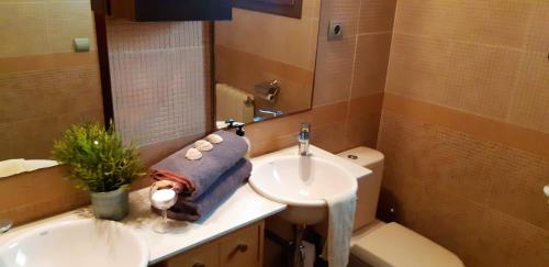 a bathroom with a sink and a toilet and a mirror at Ashram Villa Sunshine in Sitges