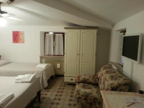 a hotel room with a bed and a couch at Dogana Vecchia - Hotel & Residence B&B Ristorante & Pizzeria in Trivignano Udinese