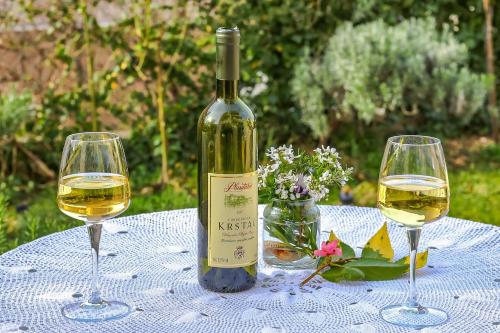 eine Flasche Wein und zwei Weingläser auf dem Tisch in der Unterkunft Apartment Castellino in Kotor