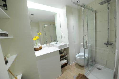 een badkamer met een douche, een wastafel en een toilet bij Duas Torres - Appartment in Funchal