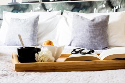 a tray with books and glasses on a bed at A casa mia in Saronno