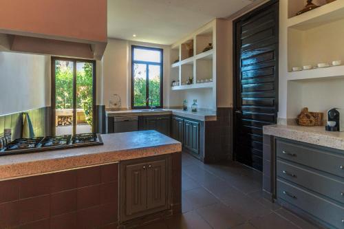a large kitchen with brown cabinets and a counter top at Villa 69 Samanah Golf Country Club in Ala el Ma