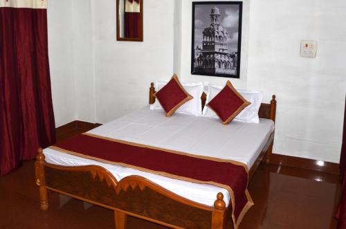 1 dormitorio con 1 cama con sábanas y almohadas blancas en Gajanand Guest House, en Jaisalmer