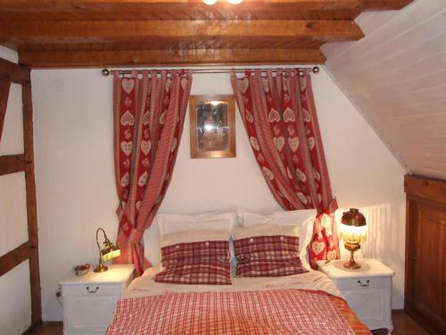 - une chambre avec un lit et des rideaux rouges dans l'établissement Chambre d'Hôtes "Au Vigneron", à Triembach-au-Val