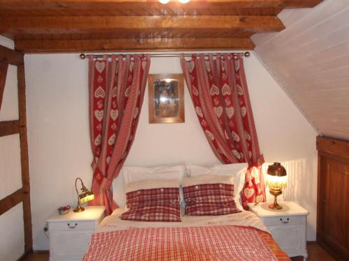 Schlafzimmer mit einem Bett mit roten Vorhängen in der Unterkunft Chambre d'Hôtes "Au Vigneron" in Triembach-au-Val