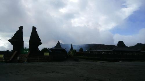 a group of buildings with mountains in the background at Budhis Home in Bromo
