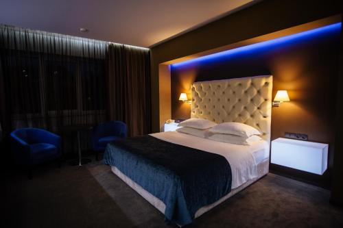 a hotel room with a bed and a blue light at LH Hotel&SPA in Lviv