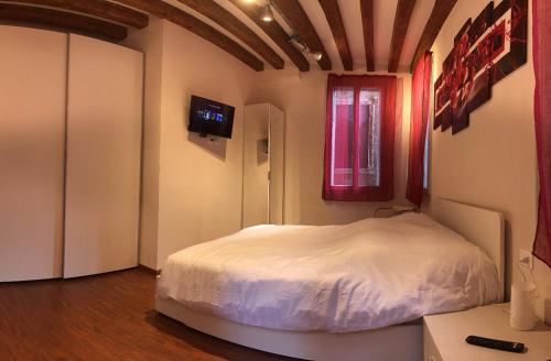 ein Schlafzimmer mit einem weißen Bett und einem Fenster in der Unterkunft Ca' Terlotta in Venedig