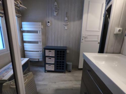 a bathroom with a sink and a counter and a door at La perle des Bains in Trouville-sur-Mer