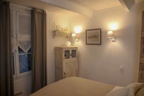 a bedroom with a bed and a window and lights at La perle des Bains in Trouville-sur-Mer