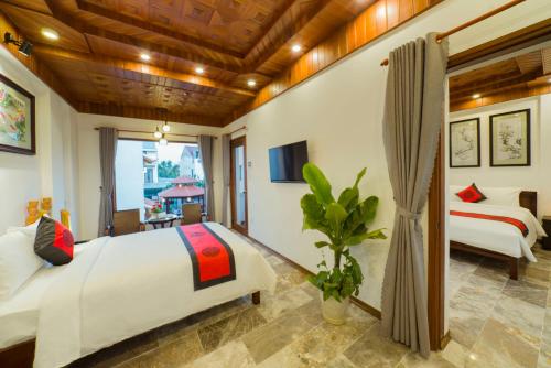 a bedroom with two beds and a tv at Green Grapefruit Villa in Hoi An