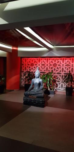 a statue in a room with a red wall at Hotel Amala in Mexico City