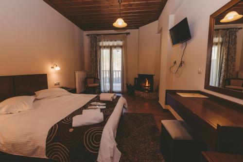 a bedroom with a large bed and a television at Thea Mainalou in Vytina