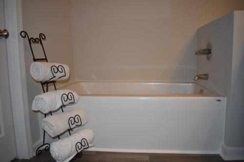 y baño con toallas blancas y bañera. en Atlanta Townhome, en Atlanta