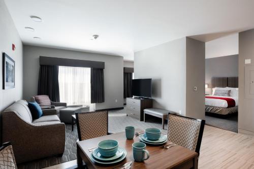 a living room with a couch and a table with chairs at StoneHill Lawrence, Trademark Collection by Wyndham in Lawrence