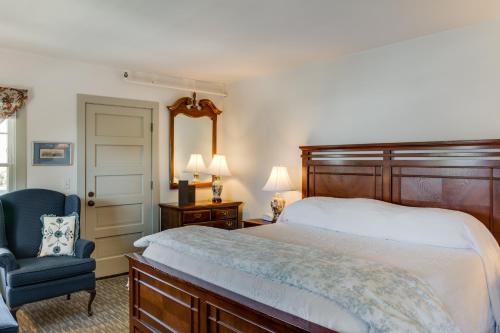 a bedroom with a large bed and a blue chair at First Colony Inn in Nags Head