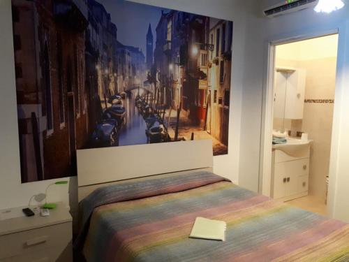 a bedroom with a bed with a painting on the wall at Comfort Murano room in Murano