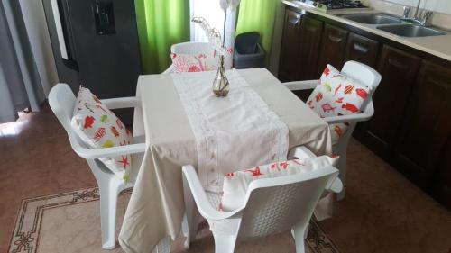 a kitchen with a white table with chairs and a sink at Apartamento Frente Al Mar in San Felipe de Puerto Plata