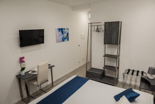 a bedroom with a bed and a tv on a wall at B&B Elegance in Taormina